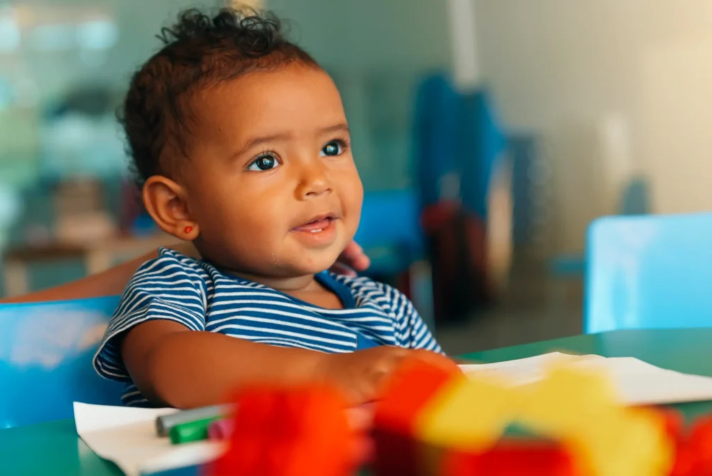 Close up of a happy baby playing with toy blocks.