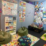 A colorful room filled with various toys and dolls scattered across the floor, creating a playful atmosphere.