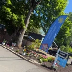 A Day Care sign featuring colorful flowers and a waving flag, inviting customers to explore My Little Twins Daycare facility.