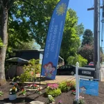 A Day Care sign featuring colorful flowers and a waving flag, inviting customers to explore My Little Twins Daycare facility.